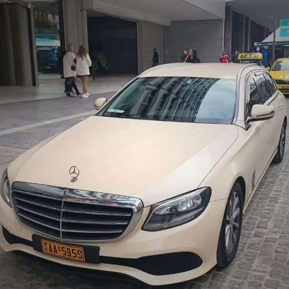 Cream Mercedes estate taxi parked on a paved city street